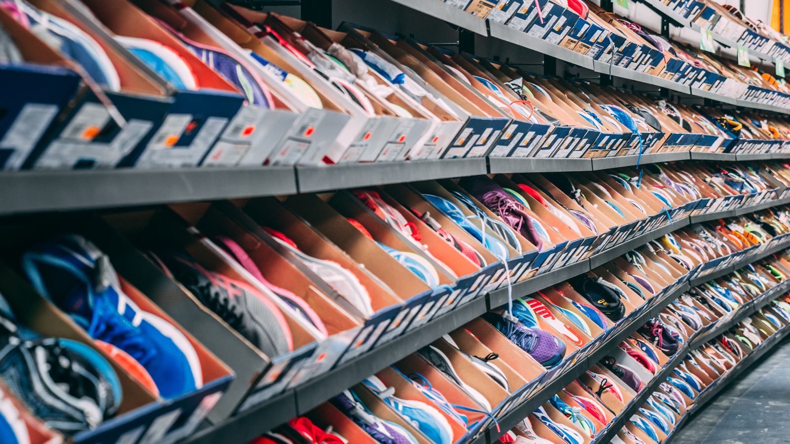 Estantes llenos de cajas de zapatillas de colores, ordenadas por modelo.