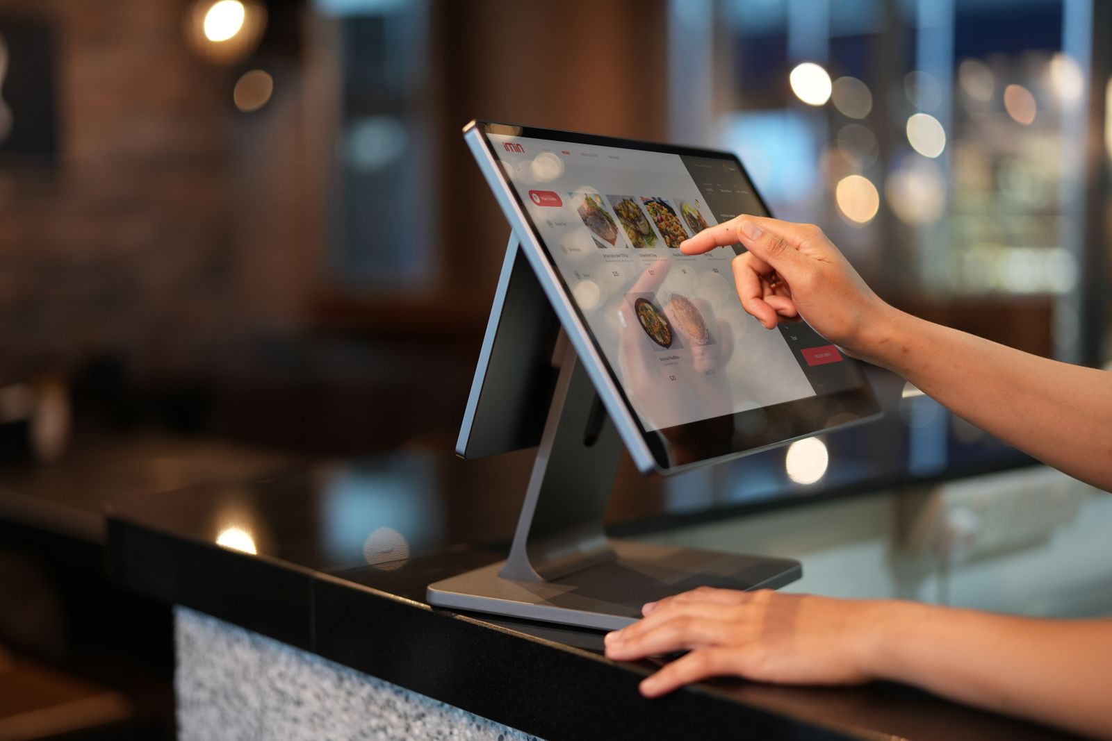 Una mano toca la pantalla de una tableta en el mostrador de una tienda.